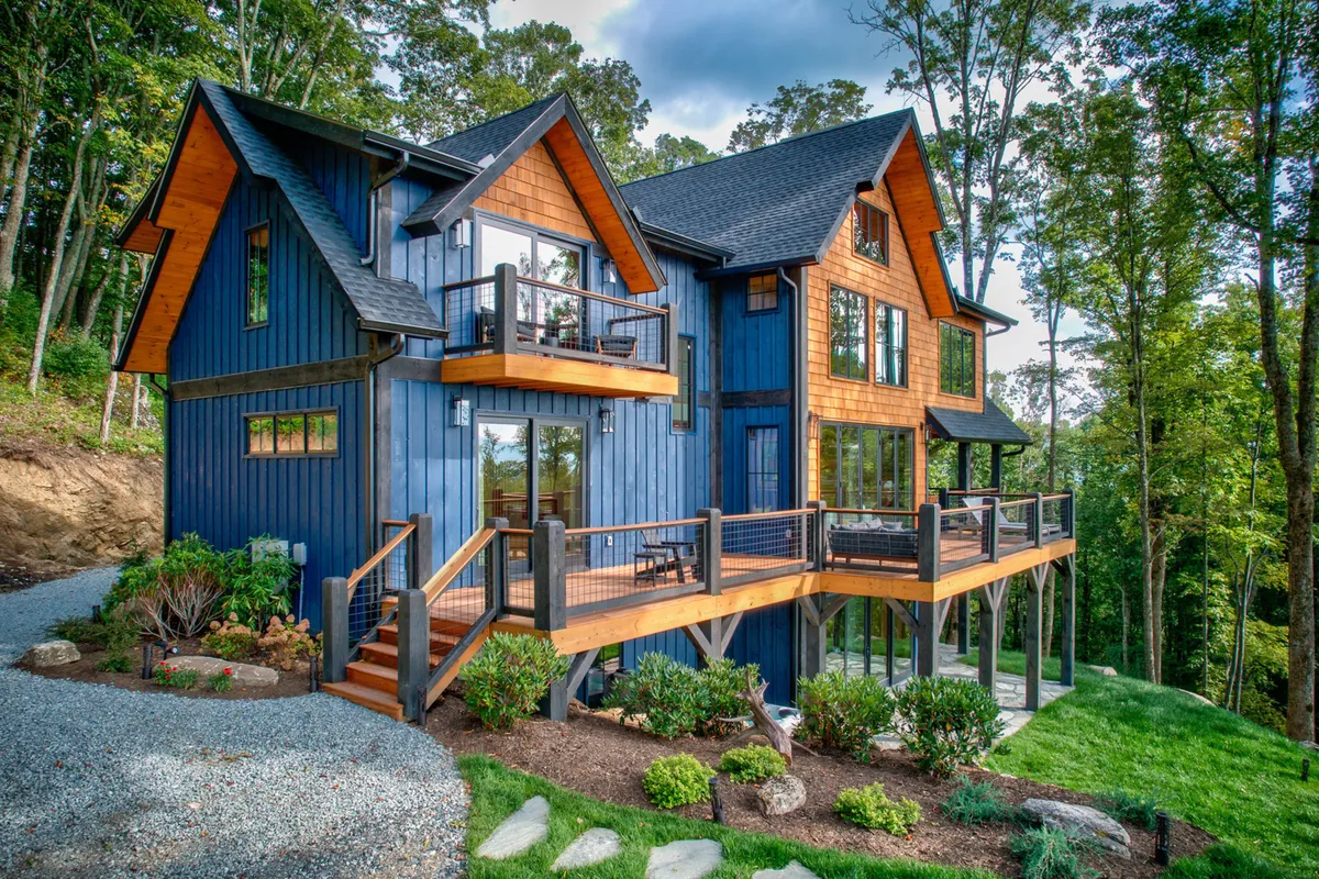 An exterior perspective of the large deck, beautifully set against lush greenery. The warm wooden tones and blue accents invite users outdoors, suggesting seamless transition from the living space to the panoramic deck mentioned in the section.